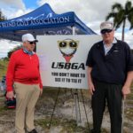 Tony and coach in front of USBGA logo sign